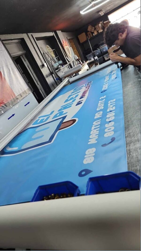 Blue printed vinyl banner on the production table at Xenix Graphics