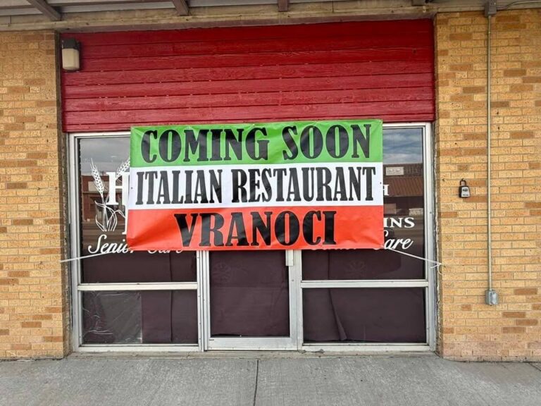 Coming Soon Italian Restaurant Vranoci banner hung in a storefront window, printed by Xenix Graphics